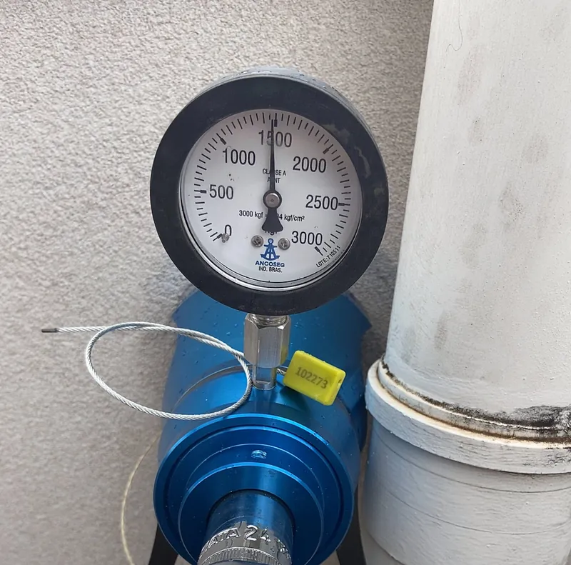 Dinamômetro marcando a carga do teste de arrancamento em um ponto de ancoragem